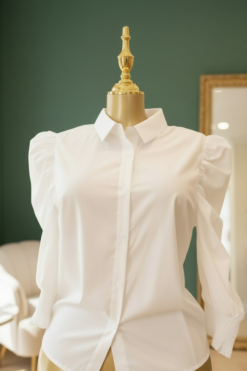 White blouse on a mannequin against a green wall
