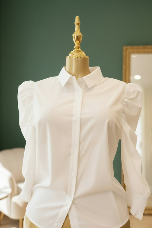 White blouse on a mannequin against a green wall